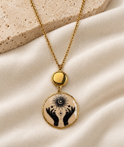Collier avec pendentif mains beige et détails dorés