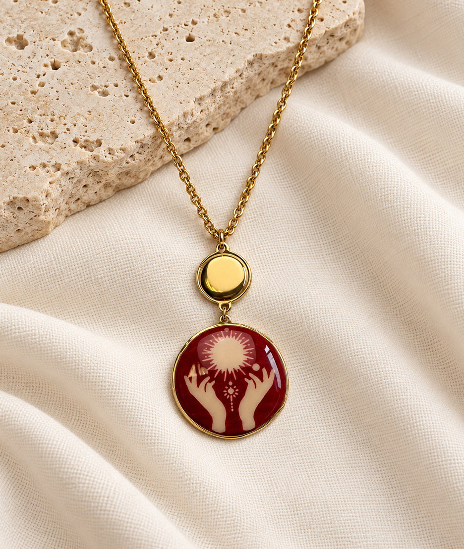 Collier avec pendentif mains rouge et détails dorés