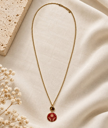 Collier avec pendentif mains rouge et détails dorés