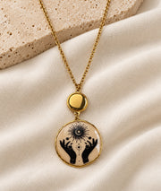 Collier avec pendentif mains beige et détails dorés