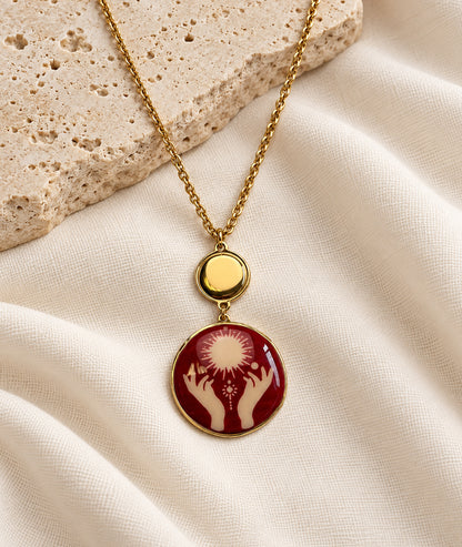 Collier avec pendentif mains rouge et détails dorés