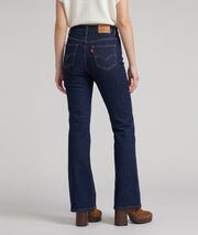 Jean bootcut femme brut taille haute porté avec gilet écru et bottines camel