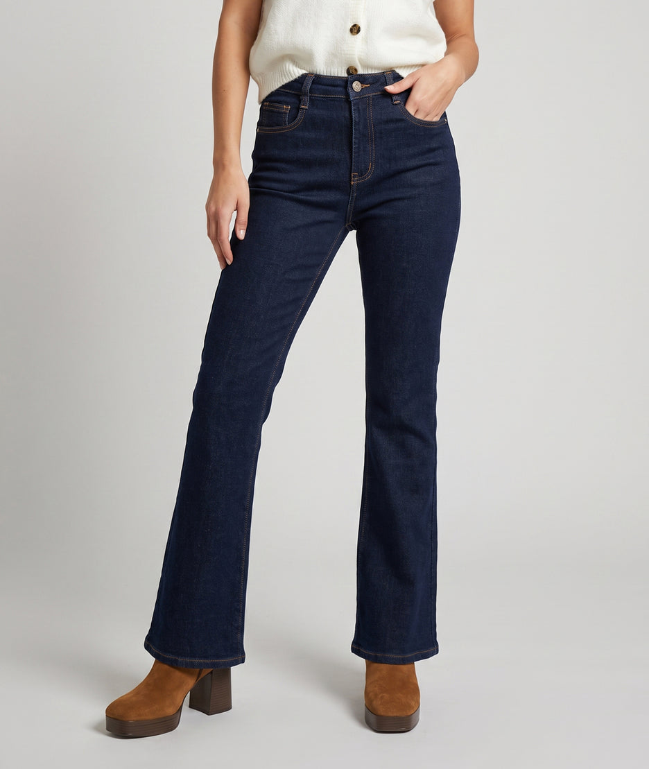 Jean bootcut femme brut taille haute porté avec gilet écru et bottines camel