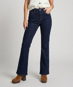 Jean bootcut femme brut taille haute porté avec gilet écru et bottines camel