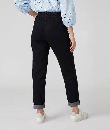 Pantalon Magali noir en jean coupe carotte à taille élastique porté de dos — Carnaby